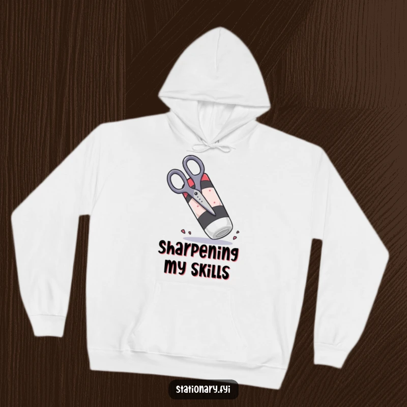 Funny scissors attempting to chop a giant rubbery eraser, depicted on a cozy hoodie for humor.