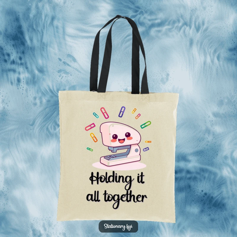Funny Tote Bag with a smiling stapler juggling colorful paper clips, great for carrying work or school supplies.
